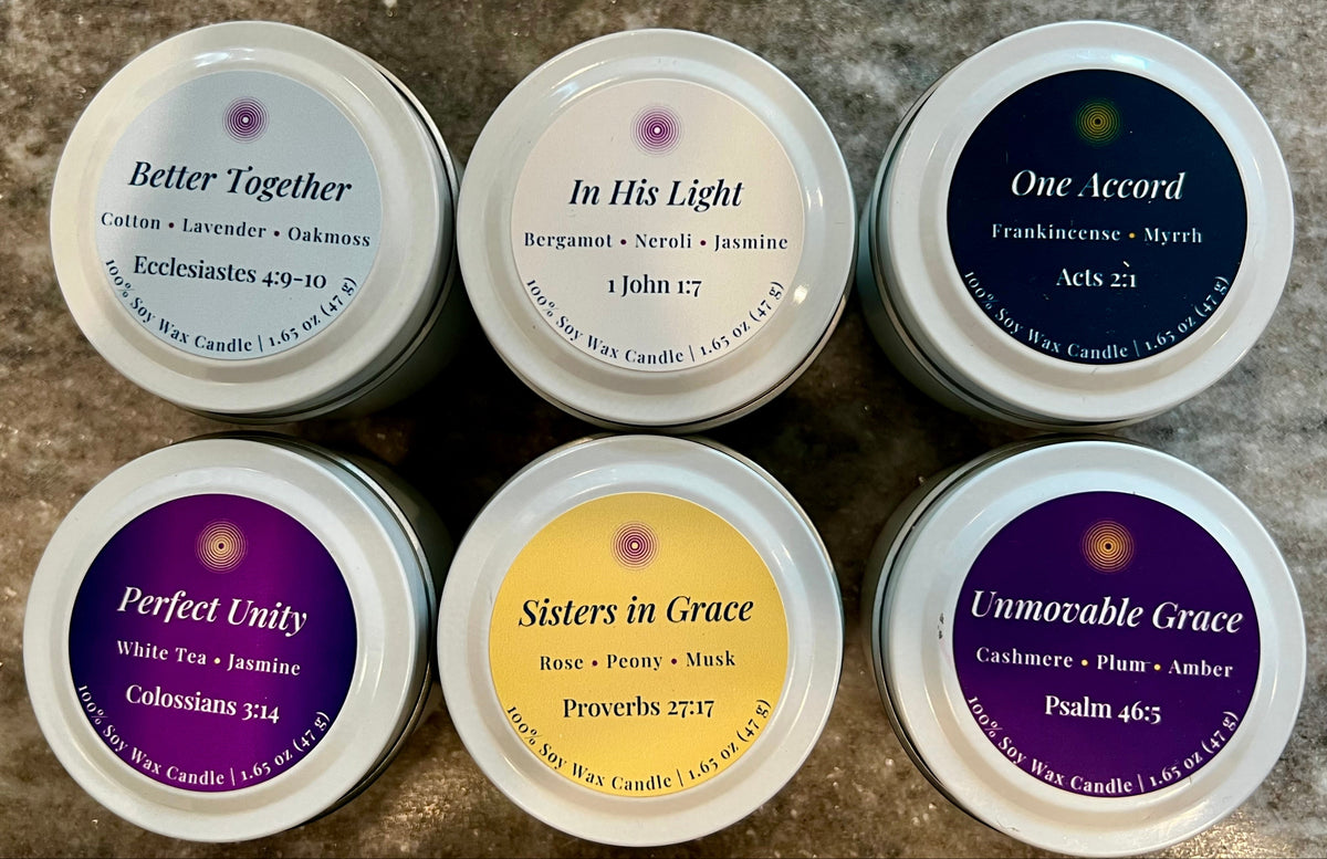 Six small candles with labels on a textured surface