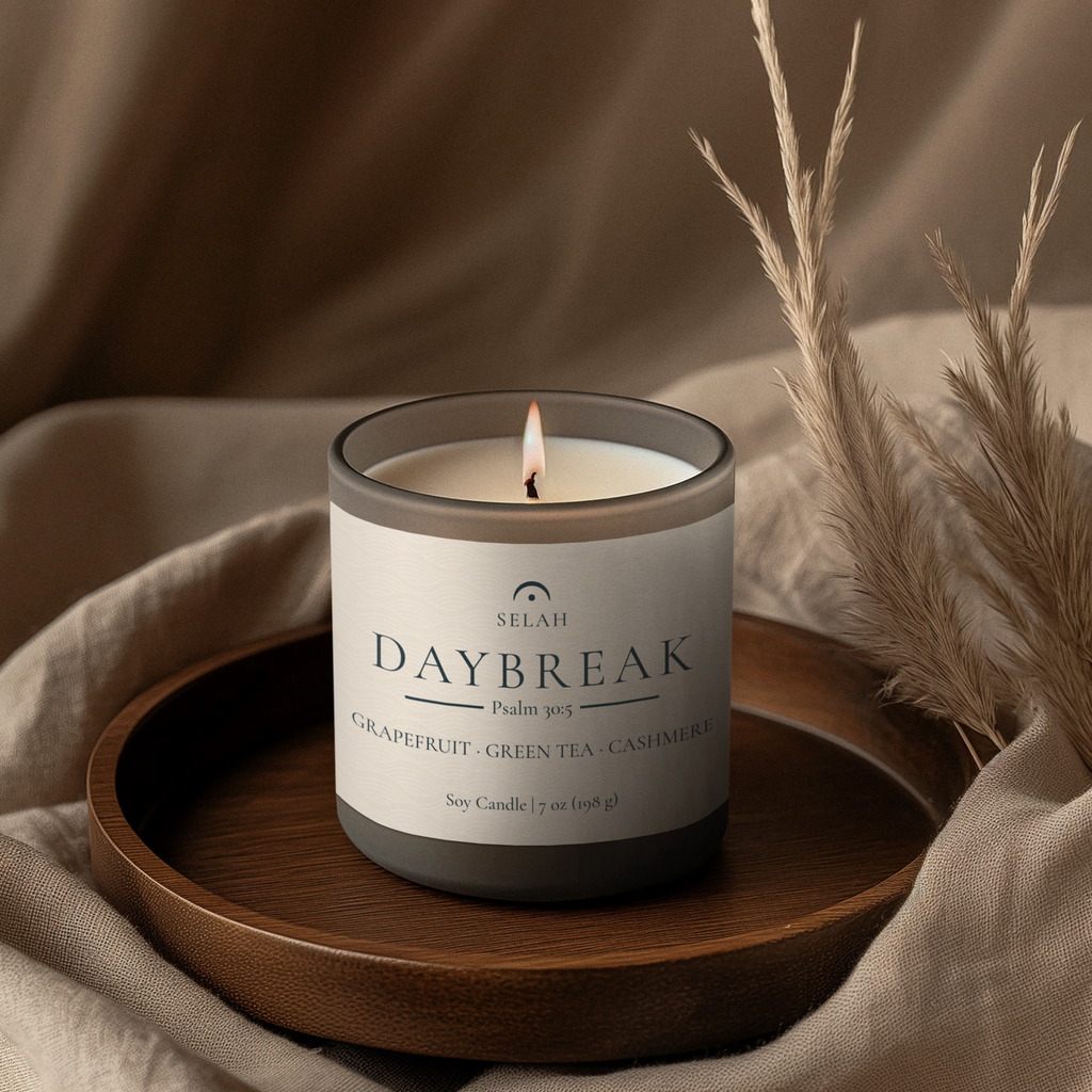 Selah Daybreak candle on a wooden tray with a neutral background